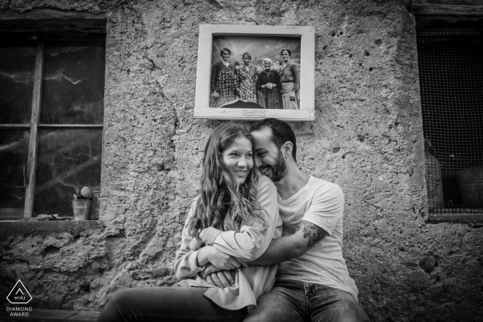 Séance de fiançailles à San Antonio del Pasubio - Vicence - Italie couple dans une petite ville de montagne où des photos des anciens habitants sont accrochées aux murs des maisons