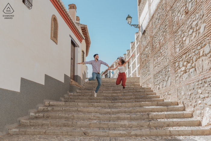 Un couple de Grenade saute dans les escaliers lors de leur séance photo avant le mariage en Espagne