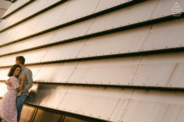 A Stavanger couple is hugging in front of a wall at sunset in Norway