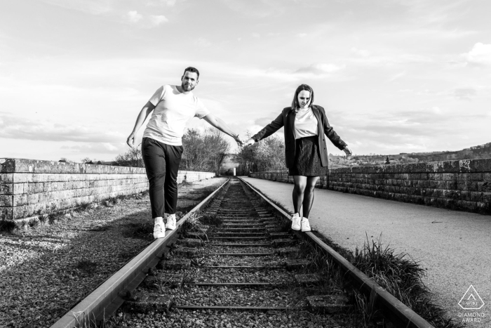 BW portrait from Clécy created as the bride and groom walk on railway tracks