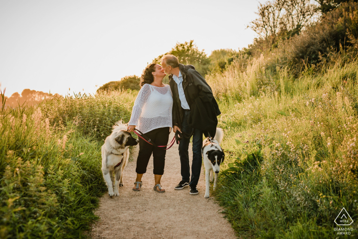 Sur un chemin de terre à Breskens, le couple s'embrasse lors d'une promenade avec leurs chiens