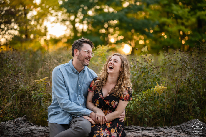 At the West Ridge Nature Center, a Chicago couple sits for an engagement portrait in warm afternoon light during a fall session in IL