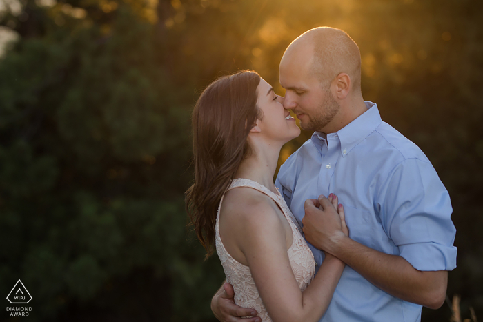 CO couple portrait with hands on chest mid kiss at Mt. Falcon