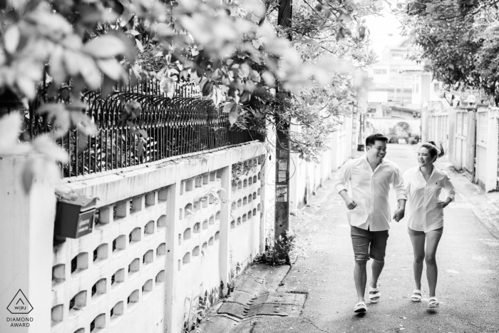 The engaged couple ran and posed in a streetscape backdrop of a narrow back alleyway, exercising their love for one another The Bangkok streetscape provided the perfect backdrop for the couple's intimate picture session, as they ran through a narrow back alleyway, exercising together