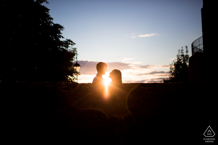 The couple in Oingt, France wait in anticipation of a sunset kiss during their engagement photo session