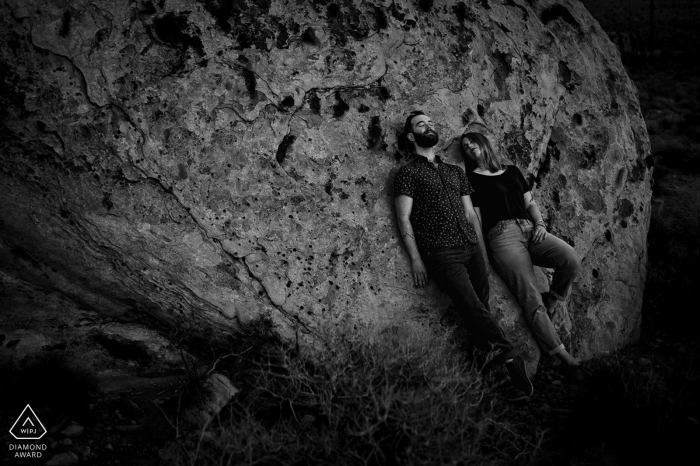 The couple leaned against a solid rock at Red Rock Canyon, basking in the peaceful time together The young couple embraced the moment, leaning against a majestic rock in the canyon