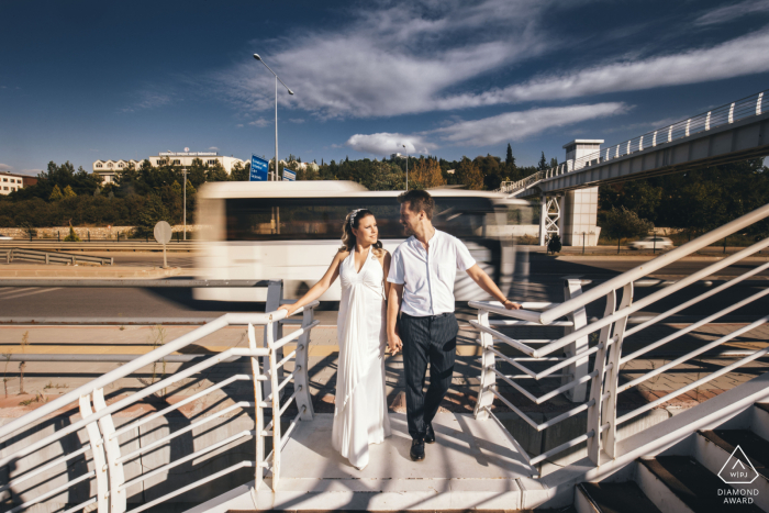 Canakkale's romantic streets witnessed a blissful engaged couple, in love, strolling as a bus passed Canakkale street engagement session of a couple walking with a bus passing by