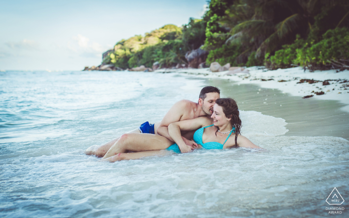 Beach Portrait Session at Anse Gaulette, La Digue, Seychelles: Couple's Pre-Wedding Relaxation by the Shore A couple enjoys a pre-wedding beach portrait session at Anse Gaulette in La Digue, Seychelles, as they relax in the waves lapping on the shore