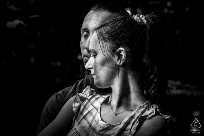 A softly lit black and white image of Andlau, Alsace, France captures the beauty of light and shadows in an engagement portrait