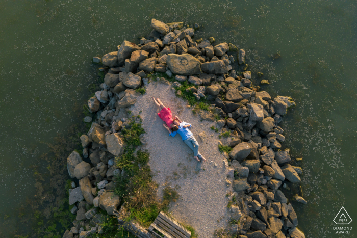 An engagement portrait captures a couple patiently anticipating the sunset at the beautiful Trasimeno Lake in Perugia, Italy