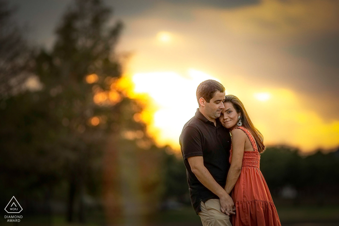 Houston, Texas: A Majestic Sunset Embrace - An Intimate Engagement Session Captured and Crafted by a Houston Wedding Artist Captured in Houston, Texas, this intimate engagement session showcases a couple's passionate embrace against a natural backdrop, just before sunset, beautifully photographed by a creative and artistic Houston wedding photographer.
