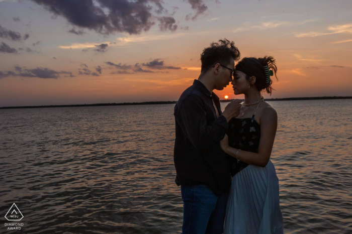 Dallas Dreams: A Breathtaking Engagement Portrait Amidst a Golden Sunset In Dallas, Texas, a WPJA wedding photographer captures a stunning engagement picture of a couple enjoying the golden sunset by the water