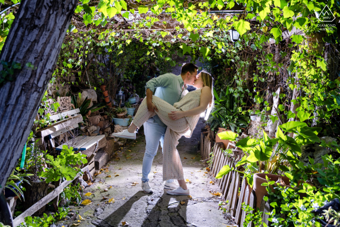 During their pre-wedding photo shoot at Castillo de la Iruela in Spain, the couple lovingly kissed and posed in a playful manner, surrounded by lush greenery.