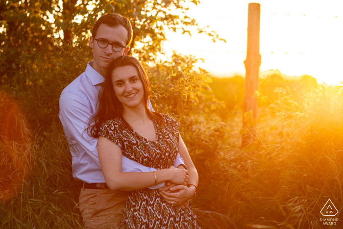 Photo of an engaged couple posing at sunset in the town of Béruges.