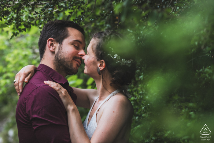 A beautiful embrace captured by a France WPJA wedding photographer at Chemin de la Mâture, Pyrénées Atlantiques. The couple share a tender kiss while descending a forested path.