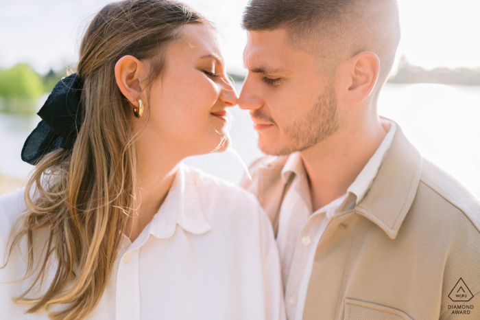 Captured at Belle Isle Park in Châteauroux, the engaged couple is caught in a tender scene, tempted to share a kiss amidst the water surroundings.