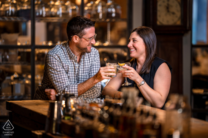 In Sono 1420, an engaged couple sits at a bar, enjoying a drink together. Under soft studio-style lighting, their intimate toast captures the warmth and connection of their engagement, highlighting their shared joy and anticipation.