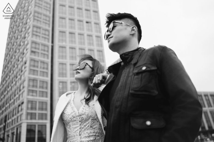 Stylish couple on the Bund, Shanghai, China, gazing ahead in a black and white low-angle shot, with sunglasses adding to their chic, futuristic vibe.