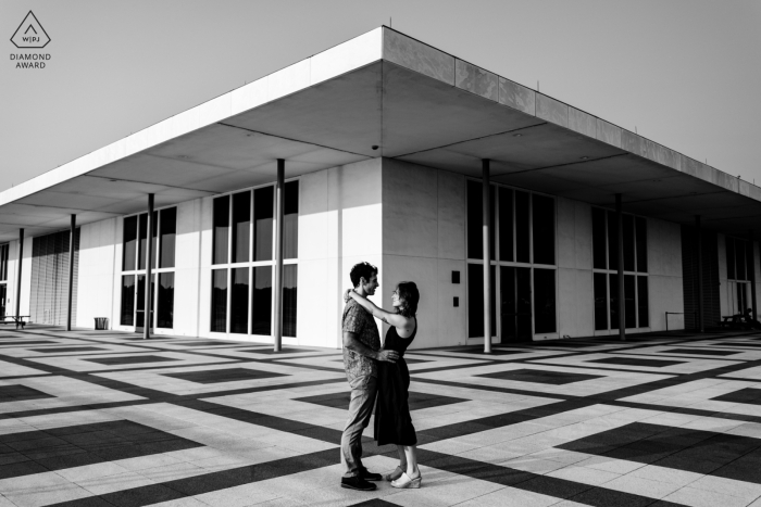 Engaged Couple Poses Outside Kennedy Center, Washington DC, Romantic Black and White Portrait Engaged couple poses outside Kennedy Center, Washington DC, in a romantic black and white portrait.
