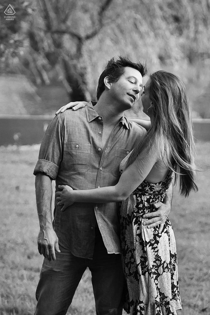 Adoring Embrace at Pine Lake Black and White Couple Portrait Session This vertical, black and white portrait at Pine Lake, GA, captures a couple adoring each other in a close embrace; she wraps him with both arms while he gives a tender, one-arm hug.