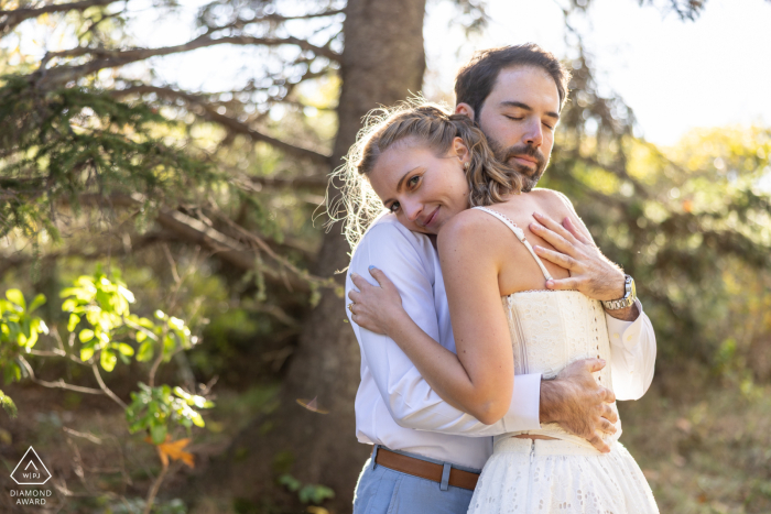 Embracing Beneath the Pines at Reid State Park Couple Portrait Session In Reid State Park, Georgetown, Maine, a couple shares a heartfelt embrace beneath a towering pine tree. Their loving connection is captured amid the natural beauty of Maine's serene coastal landscape.