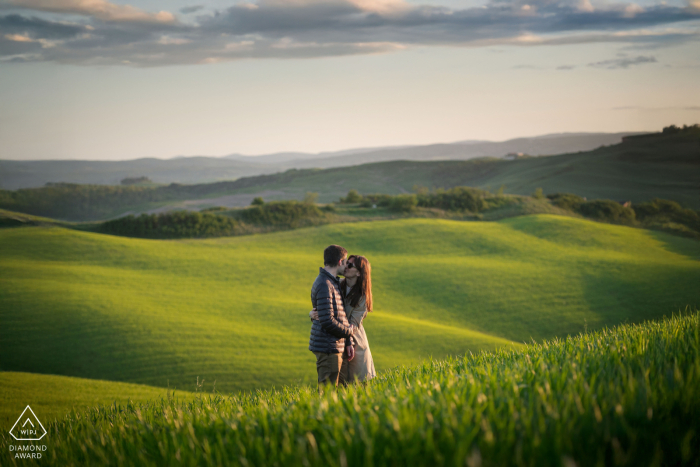 Surrounded by Rolling Green Hills in Crete Senesi Tuscany Couple Portrait Session In Crete Senesi, Tuscany, a couple portrait features them surrounded by lush greenery and the rolling green hills, showcasing the region's stunning, scenic views.