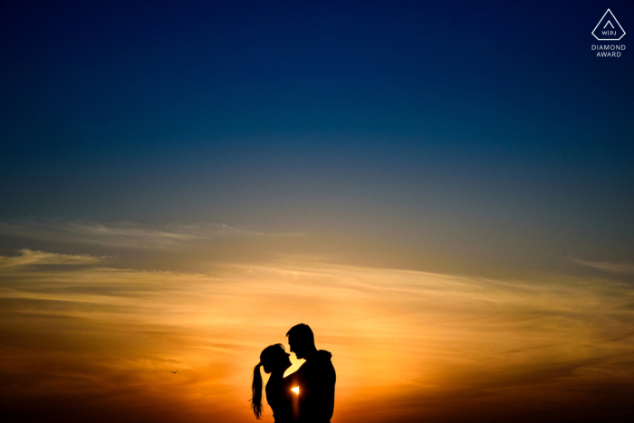 In Perez, Santa Fe, Argentina, an engaged couple poses face to face in silhouette during a golden hour sunset portrait session.