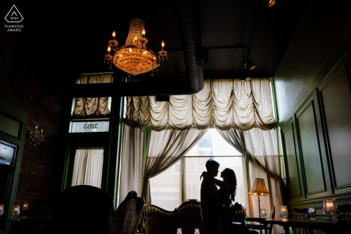 A Dramatic Silhouette Captures The Couple Amid Moody Ambiance Inside Scofflaw In Logan Square, Chicago, Illinois A dramatic silhouette of the couple is captured inside Scofflaw in Logan Square, Chicago, Illinois, highlighting their connection within the moody and stylish atmosphere of this local favorite.