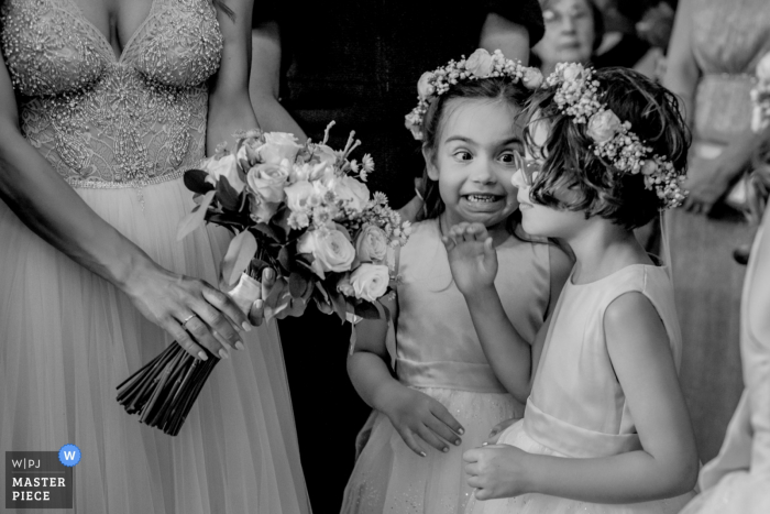 Photo by: <a href="https://www.wpja.com/contests/2018-v01-photography-competition/best-wedding-photographers/2164951">Nikos Roussis - Athens Attica</a> Athens wedding photographer captured this black and white photo of two flower girls sharing a secret while waiting for their turn to walk down the aisle