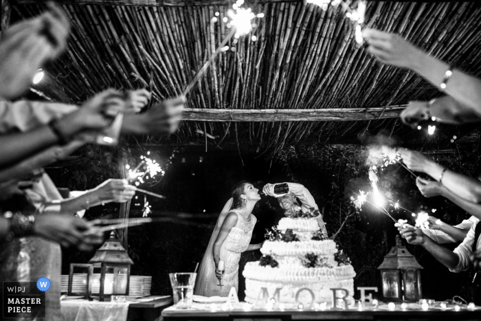 Photo by: <a href="https://www.wpja.com/contests/2018-v01-photography-competition/best-wedding-photographers/2165771">Fabio Mirulla - Montevarchi Arezzo</a> This black and white image of a bride and groom enjoying champagne straight from the bottle as wedding guests hold sparklers in celebration was taken by a Tuscany wedding photographer