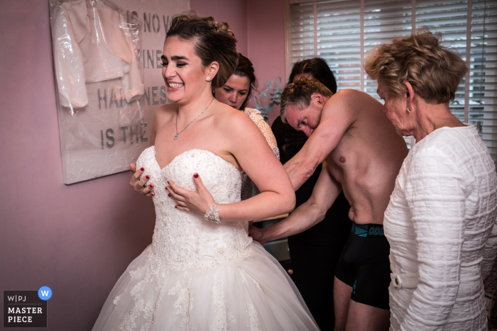 Photo by: <a href="https://www.wpja.com/contests/2018-v01-photography-competition/best-wedding-photographers/2166076">Peter Kos - Haarlem Noord Holland</a> This image of the bride getting assistance putting on her dress was captured by a Noord Hollands wedding photographer
