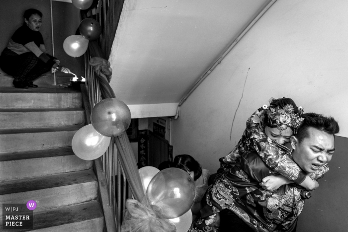 Photo by: <a href="https://www.wpja.com/contests/2018-v01-photography-competition/best-wedding-photographers/2166266">Xiaoshui Zhao - Yuxi Yunnan</a> China exhausted groom carries the bride up the steps