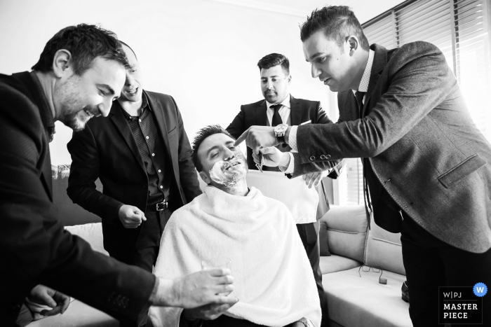 Foto door: <a href="https://www.wpja.com/contests/2018-v01-photography-competition/best-wedding-fotografen/2170761"> Vasilis Maneas - Thessaloniki </a> Veria, Griekse groomsmen scheren de grooms baard voor de bruiloft