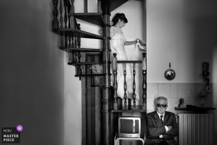 Photo by: <a href="https://www.wpja.com/contests/2018-v01-photography-competition/best-wedding-photographers/2171506">Samuele Ciaffoni - Ancona Ancona</a> Marche brides father waits as she walks down the stairs before the wedding