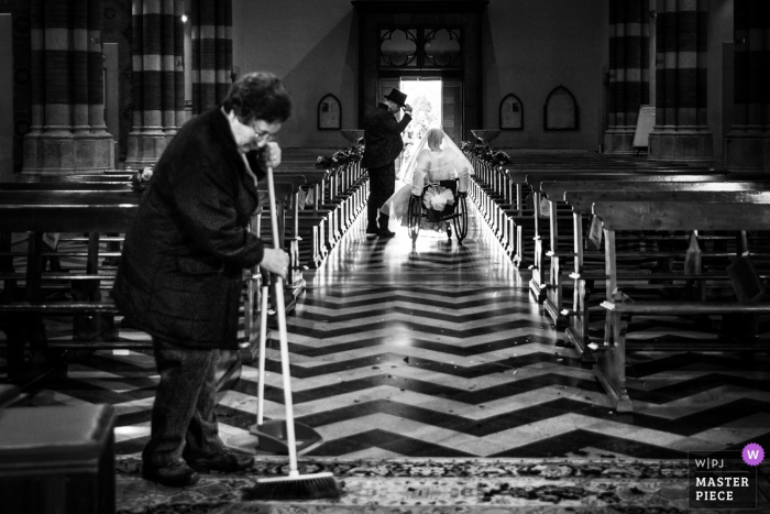 Photo by: <a href="https://www.wpja.com/contests/2018-v01-photography-competition/best-wedding-photographers/2171531">Samuele Ciaffoni - Ancona Ancona</a> Marche woman sweeps the floor as bride and groom leave the church