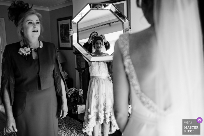 Kildare, Ireland bride looking into the mirror while getting her dress ready before the wedding ceremony