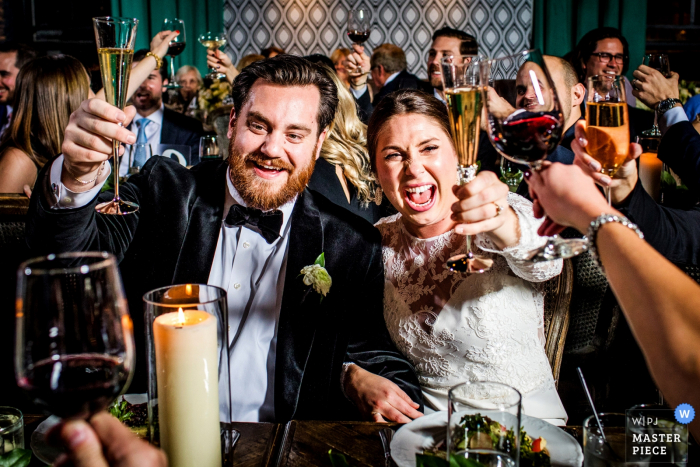 Foto von: <a href="https://www.wpja.com/contests/2018-v01-photography-competition/best-wedding-photographers/2172956"> Allison Williams - Chicago Illinois </a> The Boarding House - Hochzeit in Illinois Foto von Braut und Bräutigam, die Gäste mit Getränken in der Hand rösten