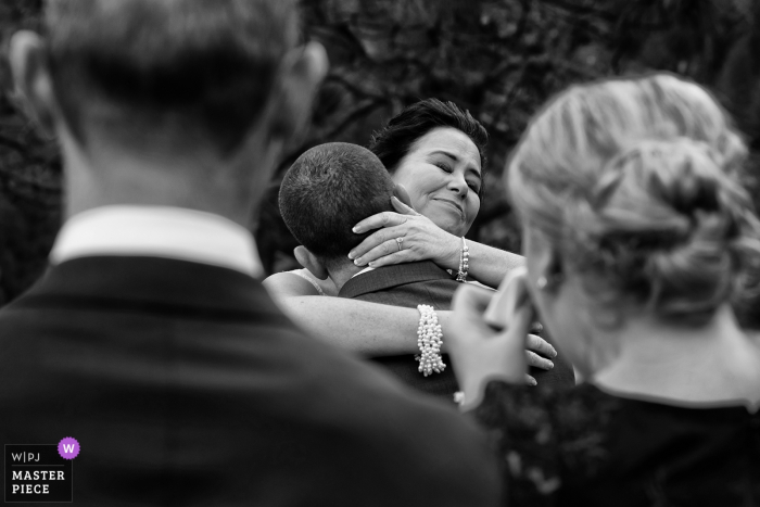 Photo by: <a href="https://www.wpja.com/contests/2018-v01-photography-competition/best-wedding-photographers/2174731">Tara Theilen - Carson City Nevada</a> Yosemite, California bride and groom hug while guests get emotional at the ceremony