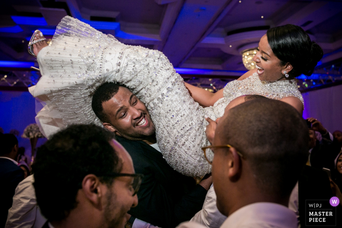Foto: <a href="https://www.wpja.com/contests/2018-v02-Fotografie-wettbewerb/best-wedding-photographers/2178631"> Christophe Viseux - Toronto, Ontario </a> Ehtipoa-Braut, die von den Groomsmen am Hochzeitsempfang getragen wird