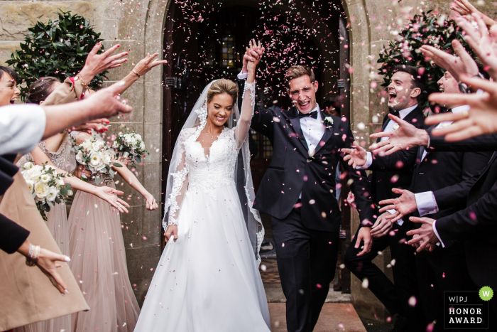 Fotografía de la ceremonia de boda en Kildare, Irlanda: los novios reciben una lluvia de confeti después de los votos de la iglesia.