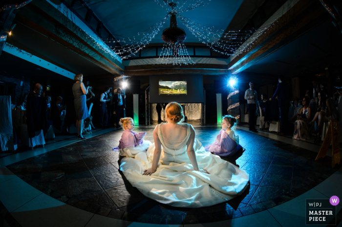 Photo by: <a href="https://www.wpja.com/contests/2018-v02-photography-competition/best-wedding-photographers/2181786">Nick Despres - Guernsey Guernsey</a> Guernsey bride sits with two girls on the dance floor at the reception