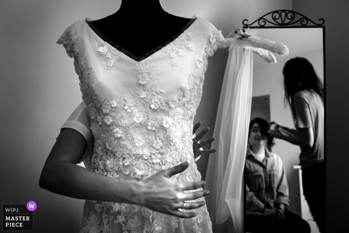 Foto por: <a href="https://www.wpja.com/contests/2018-v03-photography-competition/best-wedding-photographers/2184651"> Ufuk Sarisen - Estambul </a> La novia de Londres, Reino Unido, prepara su cabello en el espejo con el vestido delante de ella