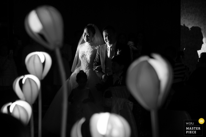 Chinesische Braut und Bräutigam lächeln nach der Hochzeit vor dem Kind