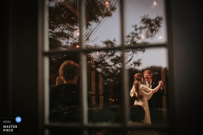 the bride and her father dancing at the wedding reception, framed in a window Dripping Springs, Texas bride and her father dancing at the wedding reception