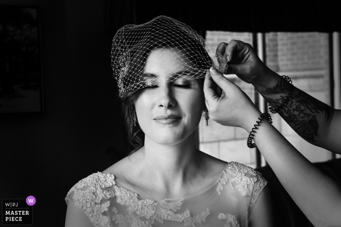Foto: <a href="https://www.wpja.com/contests/2018-v03-Fotografie-wettbewerb/best-wedding-photographers/2186546"> Adeline Leonti - Montreal Quebec </a> Montreal, Quebec-Braut, die letzte Berührung mit ihrem Kleid vor der Hochzeitszeremonie erhält