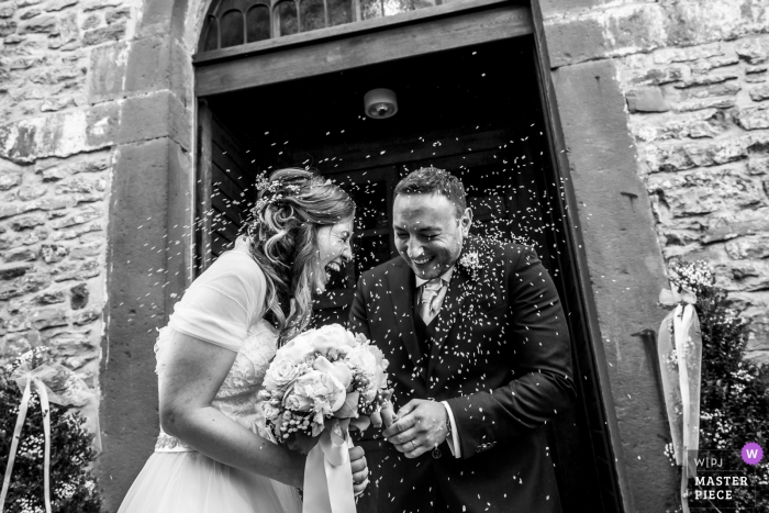 Foto door: <a href="https://www.wpja.com/contests/2018-v04-photography-competition/best-wedding-photographers/2192506"> Luigi Rota - Comomeer Lecco </a> Lombardije bruid en bruidegom lachen als rijst wordt gegooid naar hen na de huwelijksceremonie