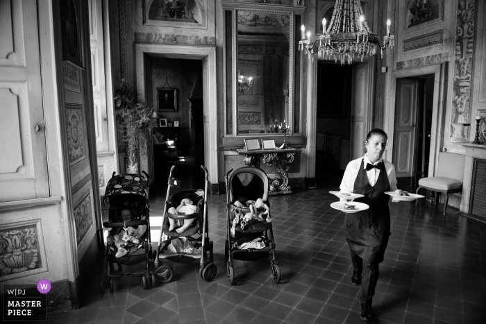 Foto por: <a href="https://www.wpja.com/contests/2018-v05-photography-competition/best-wedding-photographers/2201831"> Massimiliano Beccati - Milano Milano </a> Villa Botta Adorno, hombre de Torre d'Isola con platos de comida junto a cochecitos en la boda