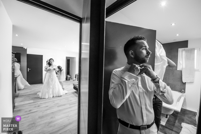 Photo: <a href="https://www.wpja.com/contests/2018-v05-photography-competition/best-wedding-photographers/2202631"> David Zaoui - Miami en Floride </a> Aubenas, France marié se prépare tandis que la mariée se prépare dans la pièce voisine avant la cérémonie de mariage