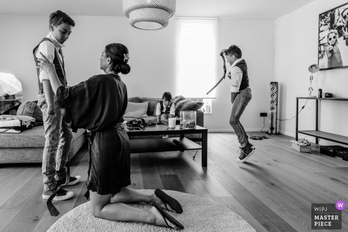 Photo by: <a href="https://www.wpja.com/contests/2018-v06-photography-competition/best-wedding-photographers/2206006">Kobe Vanderzande - Hasselt Limburg</a> Houthalen woman helping some boys get dressed for the wedding ceremony