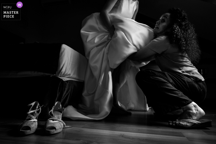 Photo by: <a href="https://www.wpja.com/contests/2018-v06-photography-competition/best-wedding-photographers/2209111">Miguel Onieva - Madrid Madrid</a> Photo of woman helping the bride get her dress on before the wedding in Sigüenza, Castilla-La Mancha